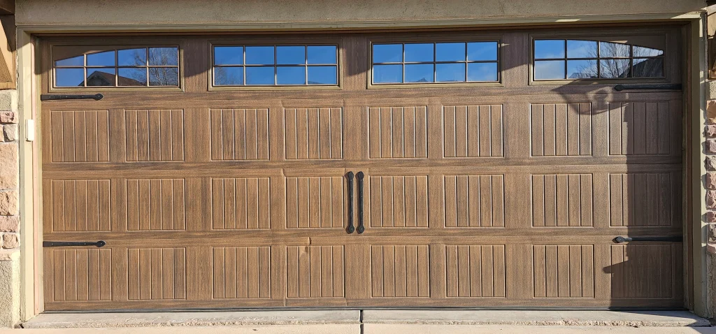 rich wood-grain texture and gridded upper window inserts beautifully illustrates the aesthetic Benefits of Custom Wood Garage Doors