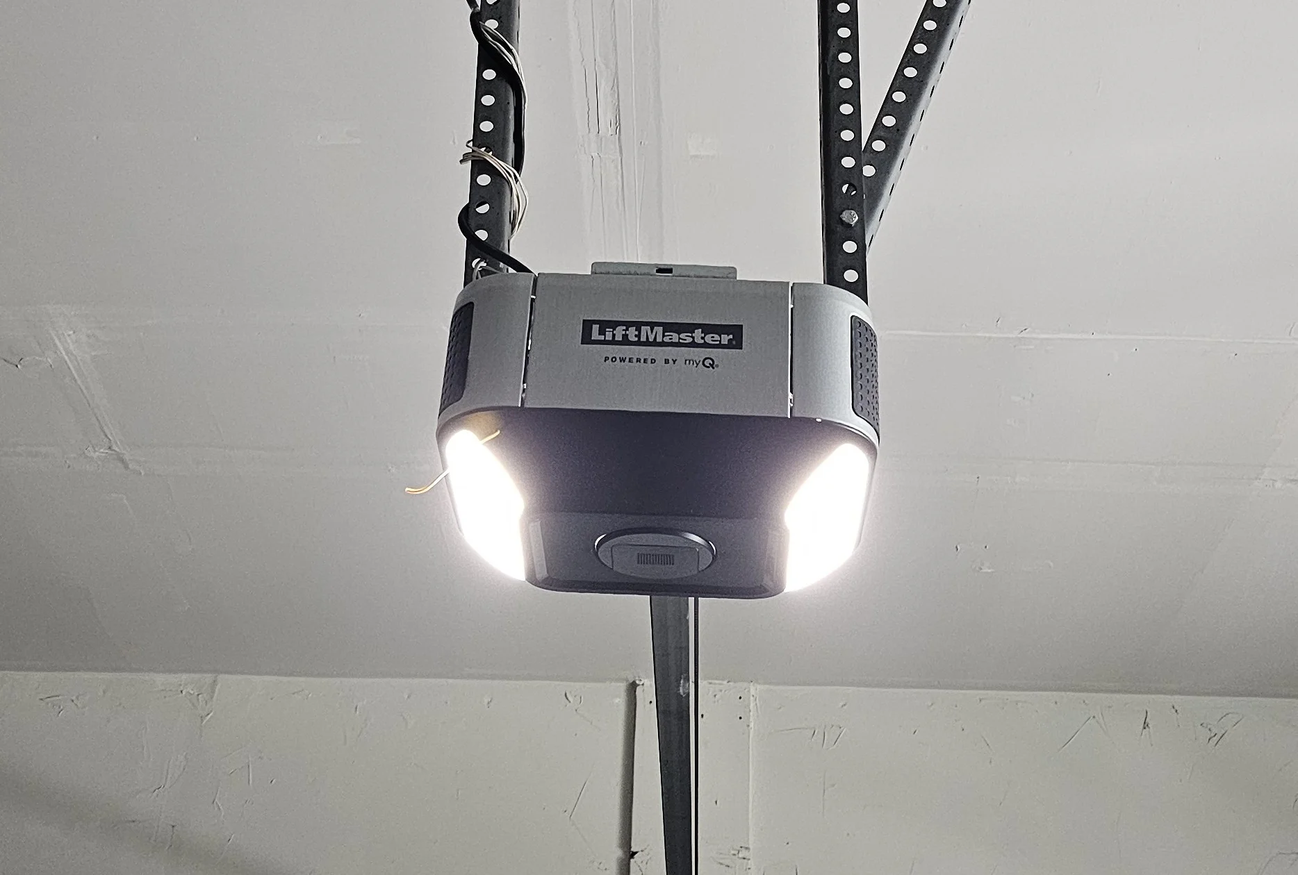 a structural ceiling highlights the core drive assembly involved in Adjusting Garage Door Opener Steps