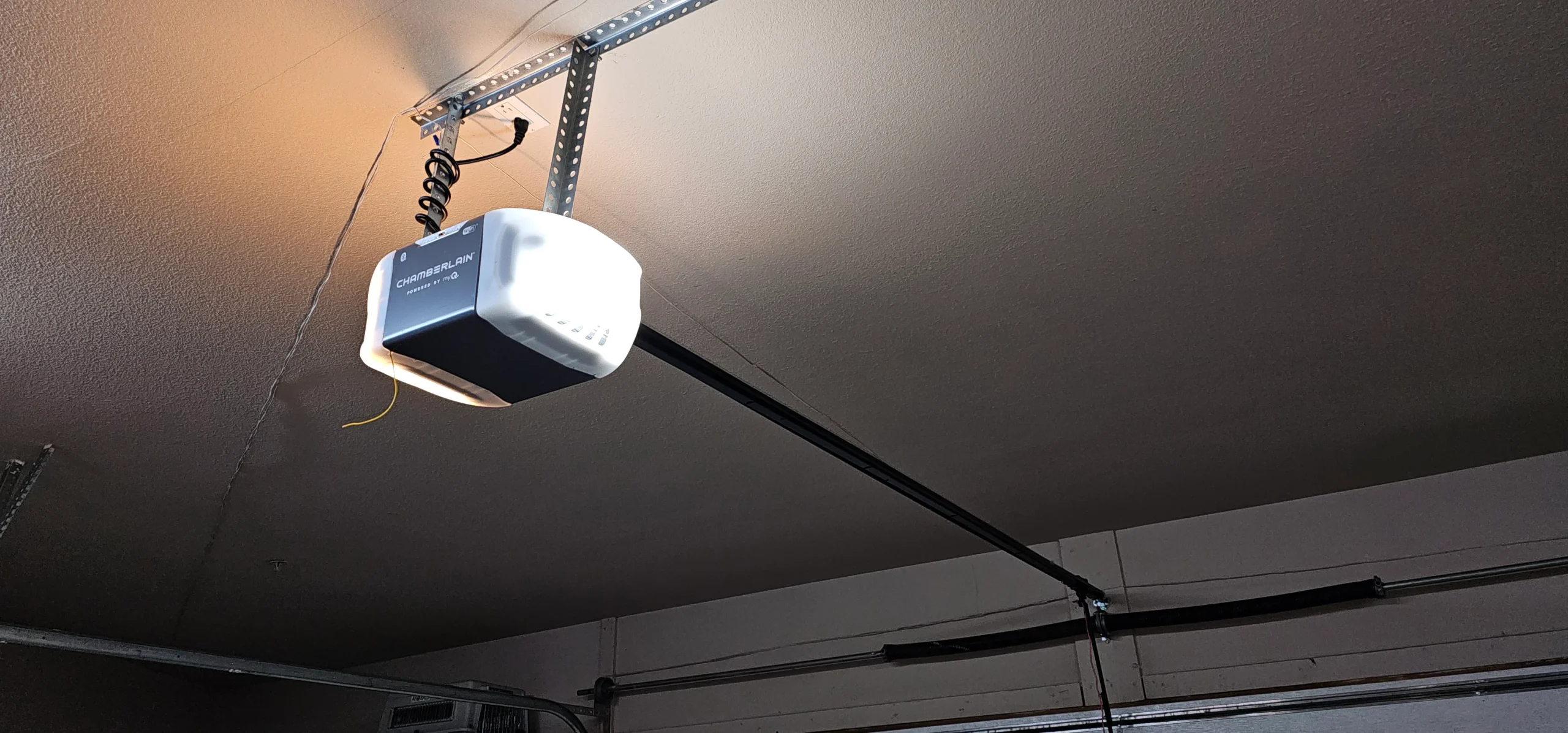 a premium Chamberlain automatic opener unit with its courtesy light illuminated perfectly frames the complete motorized system configuration featured in Professional garage door opener adjustment