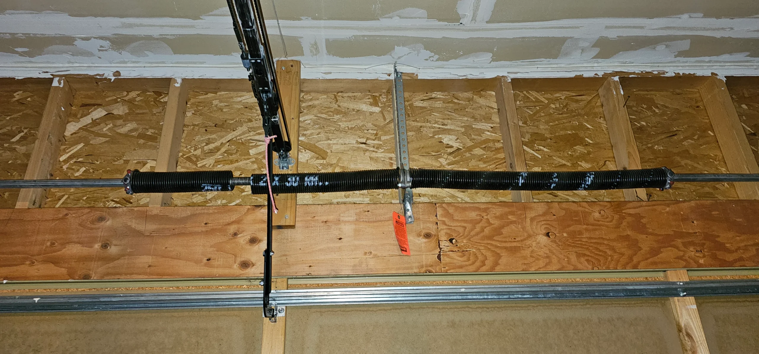 a garage assembly reveals a dual torsion spring system mounted horizontally along a metal shaft above the garage door frame, cleanly demonstrating the mechanisms discussed in Role of Garage Door Springs