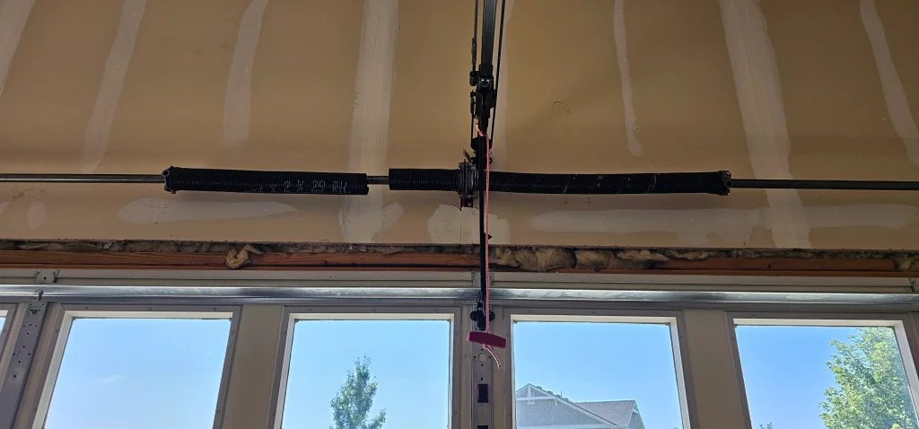 a windowed garage door frame cleanly captures the mechanical layout discussed in Signs Your Garage Door Springs Need Replacement