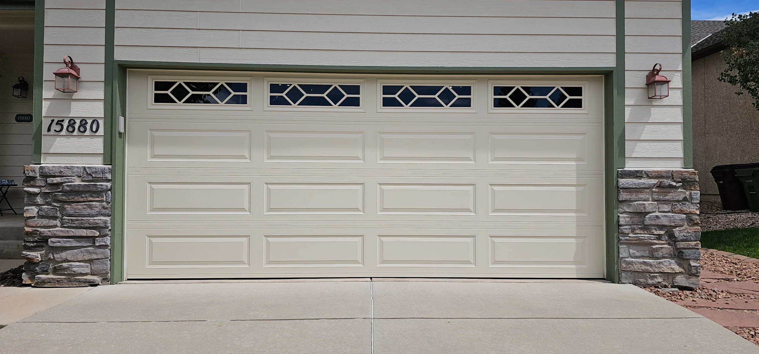 A clean, balanced exterior view of a cream-colored double-car garage door provides the baseline reference for Signs You Need Emergency Garage Door Repair.
