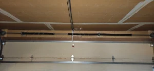 An interior, wide-angle view of a closed double-car garage door highlights the heavy-duty mechanical system featured in Critical Role of Garage Door Springs