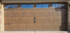 wood-grain carriage-style garage door with elegant top windows and decorative iron hardware perfectly captures the visual asset featured in What Garage Door Security Features Do Buyers Look For