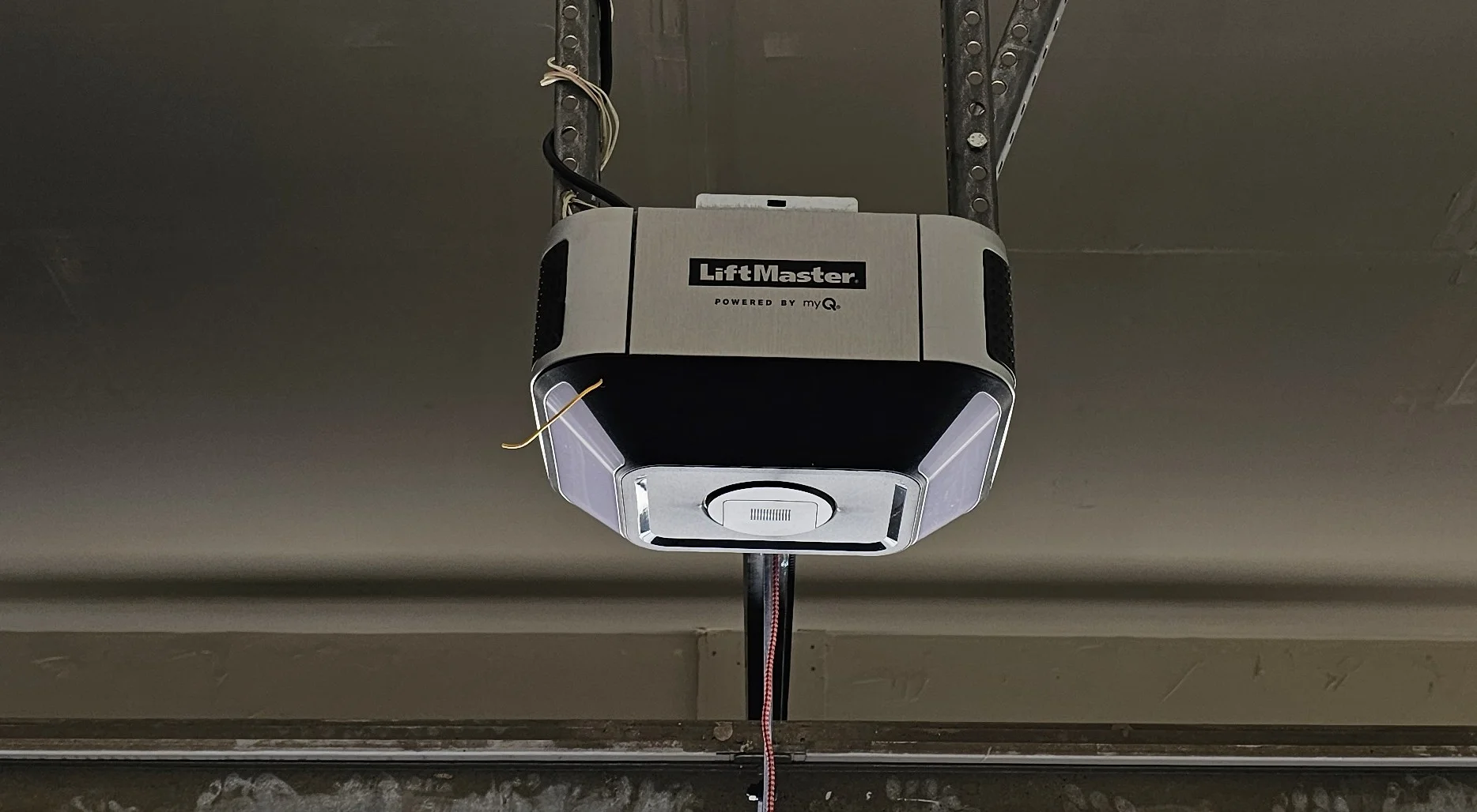 A direct, front-facing view of a ceiling-mounted LiftMaster smart garage door opener highlights the motor unit central to LiftMaster Garage Door Opener Beeping Causes